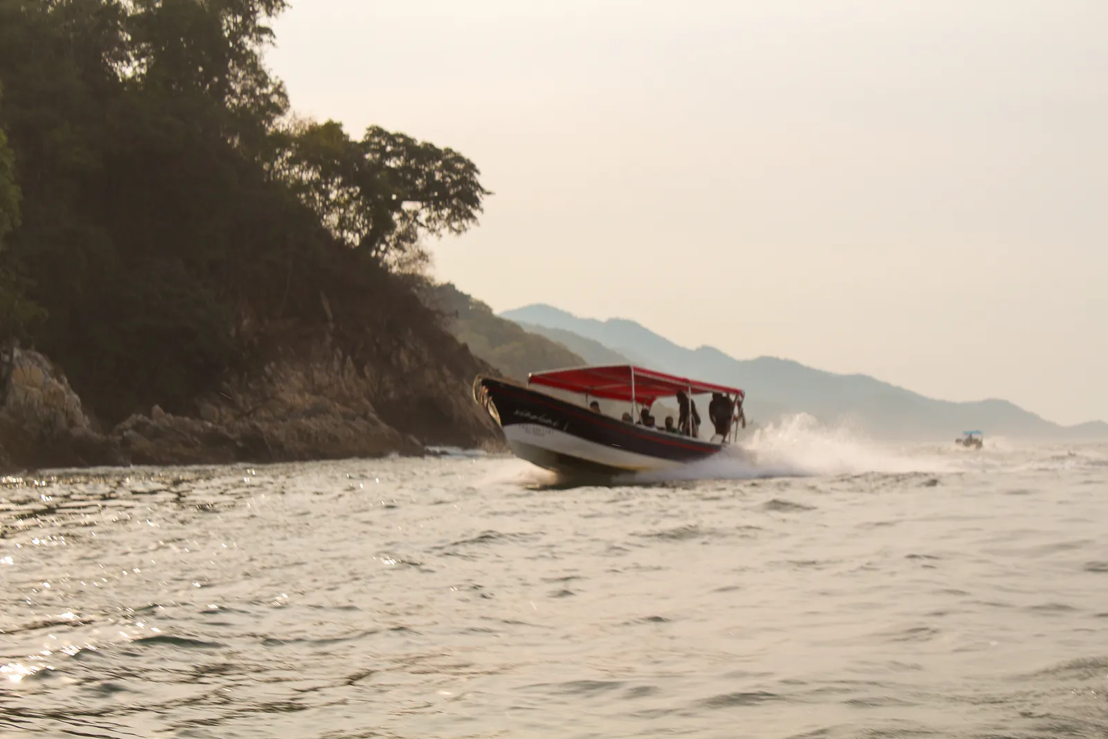 Una lancha rápida bordeando los acantilados de la costa sur