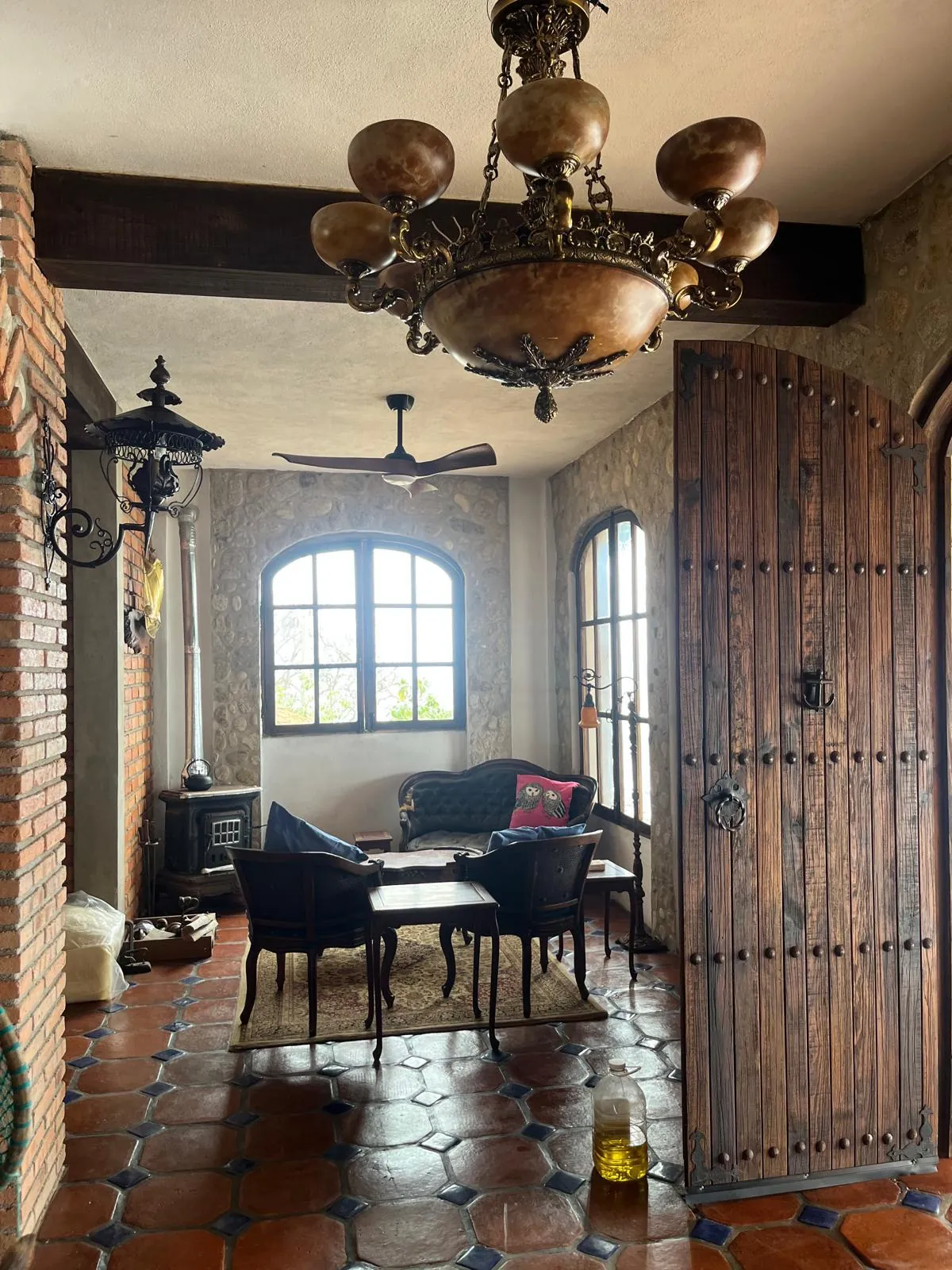 Sala de Villa Chimo con muros de piedra de río, candil y estufa de leña