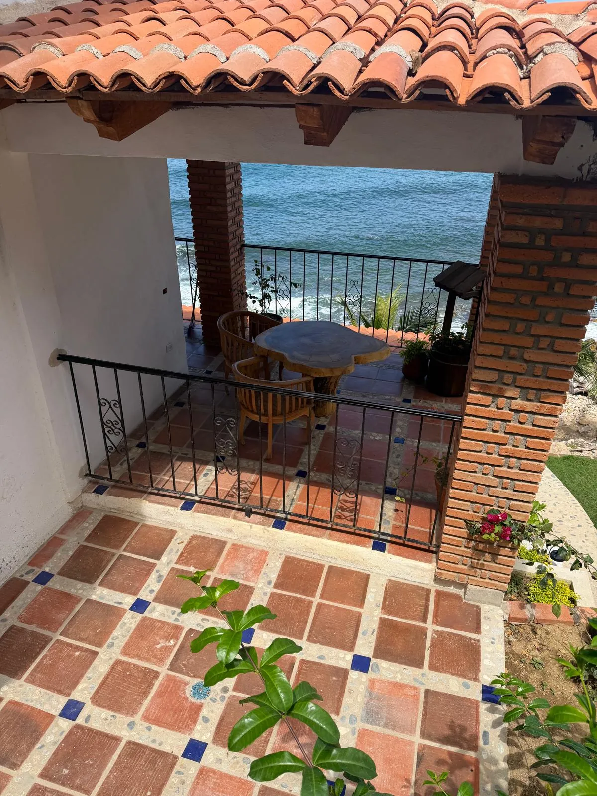 Terraza con mesa de tronco y vista abierta al océano Pacífico